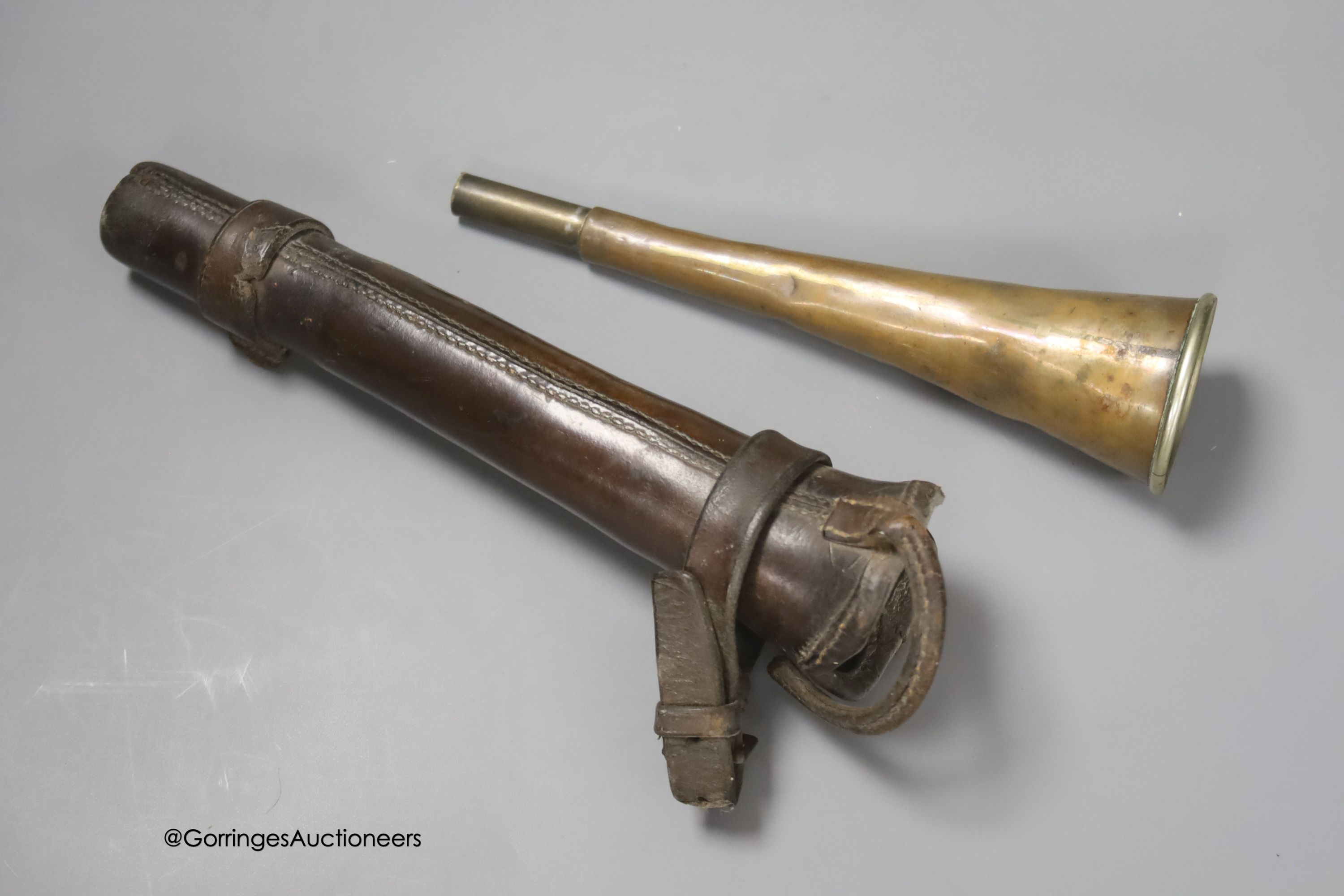 A cast iron Creedmore-type novely money bank, width 24cm, and a small copper horn, in leather case